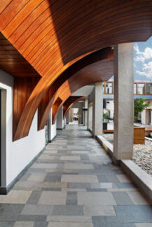 gray and white flooring with curved wood ceiling