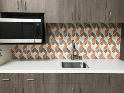 kitchen backsplash with orange, gray and white 3D square tiles over sink