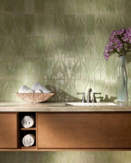 green patterned tile on bathroom wall with sink and floral vase