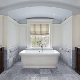 Marblesystems gray tile bathroom floor with white tub
