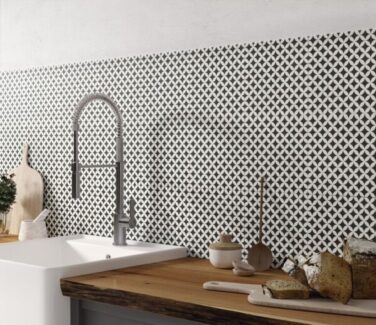 black and white diamond checkerboard pattern tile on kitchen wall with sink and cutting board countertops