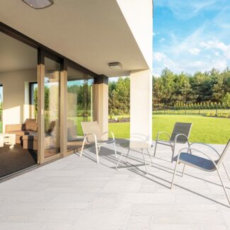 backyard patio tile with chairs and grass lawns