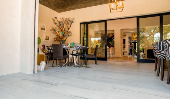 patio with white tile flooring and zebra striped chairs with open patio doors