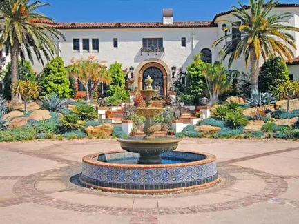 blue and gold tile fountain in backyard in front of Spanish style house