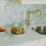 kitchen sink with green square tile back splash and muffins