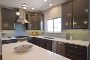 kitchen area with white topped kitchen island and gray and white zigzag pattern tile over white countertops