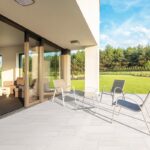 backyard patio tile with chairs and grass lawns